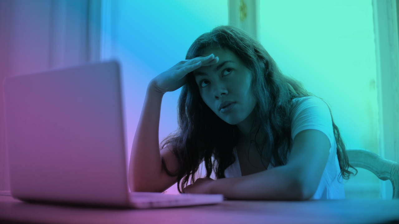 woman in front of a computer screen dealing with a headache